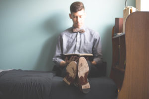 man in bow tie reading